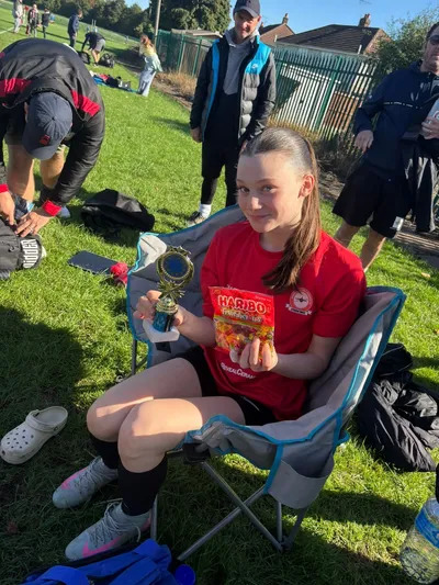 Girl holding football trophy